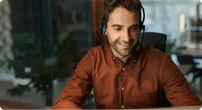 Rappresentante del servizio clienti sorridente con auricolari, che rappresenta il supporto 24/7 di Cars Iceland fornito da esperti locali del noleggio.