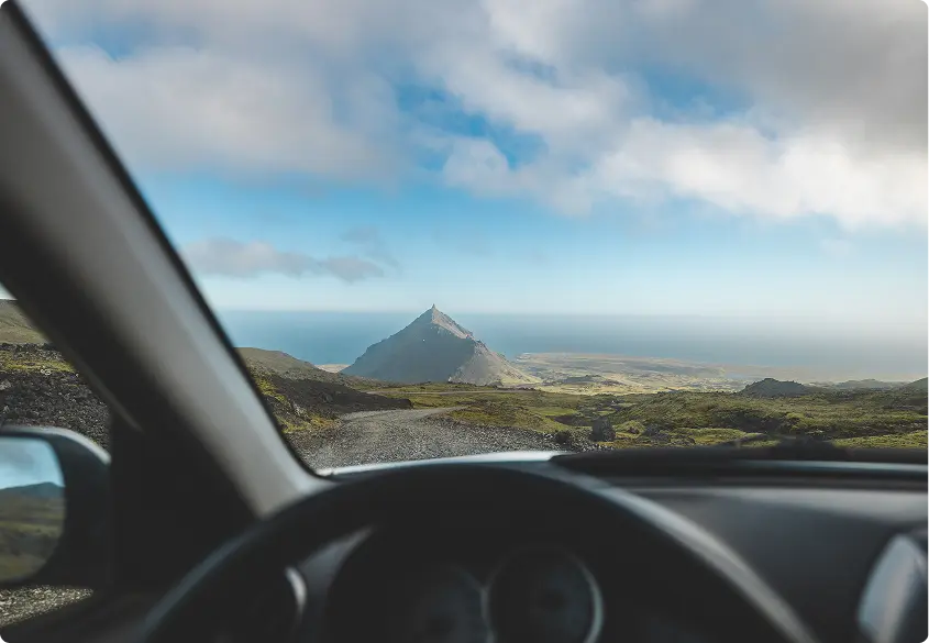 Vista aerea della panoramica costa islandese e delle strade tortuose, che mostrano i vasti paesaggi accessibili con un'auto a noleggio lungo la Ring Road.