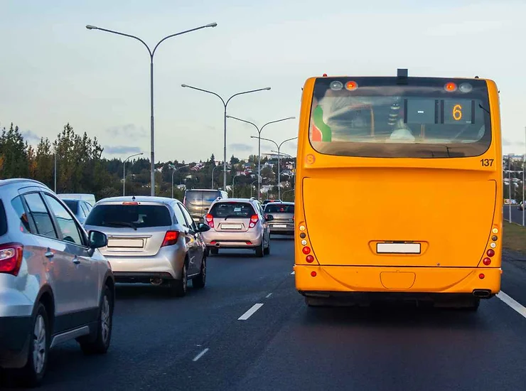Autobus giallo in una strada trafficata di una città islandese.