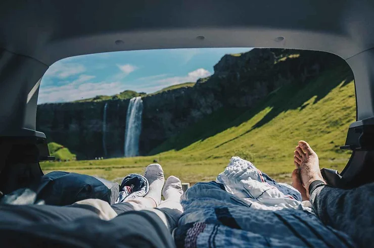 Vista dal camper su una cascata islandese immersa nel verde.