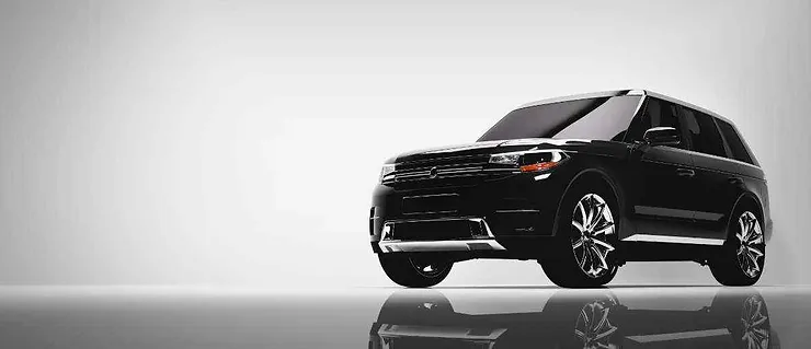 Un SUV nero moderno fotografato in uno studio con uno sfondo grigio chiaro. L'auto è elegante e riflette il pavimento lucido.