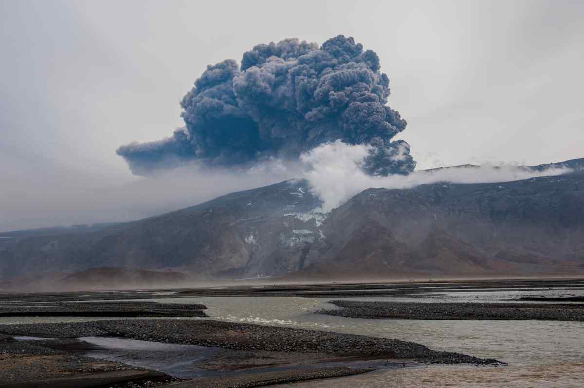 Eruzione del vulcano Eyjafjallajökull in Islanda con colonna di fumo e cenere che si alza nel cielo, evento vulcanico epico del 2010.