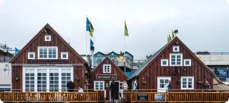 Complesso di ristoranti sul lungomare rivestito in legno di cedro, con tetti spioventi, decorazioni nautiche e bandiere colorate, fondato da esperti del settore nel 2013.