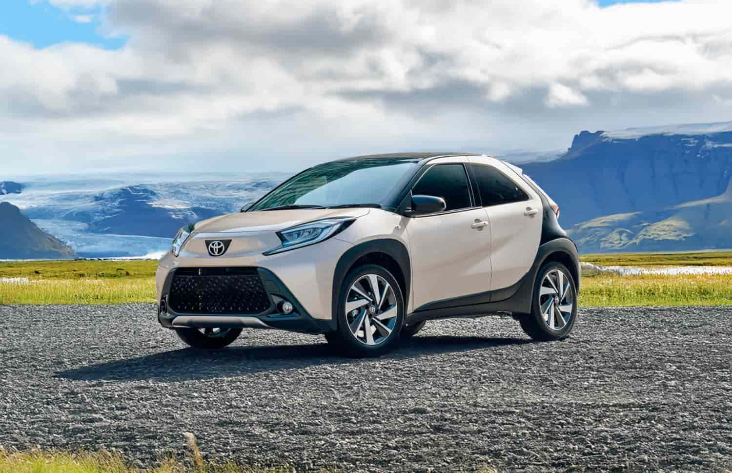 Toyota Aygo arancione brillante con cambio automatico, ideale per 4 passeggeri, compatta ed efficiente per girare le città islandesi.