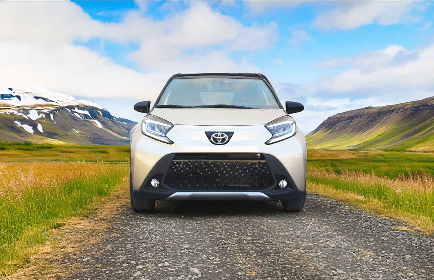 Toyota Aygo arancione brillante con cambio automatico, ideale per 4 passeggeri, compatta ed efficiente per girare le città islandesi.