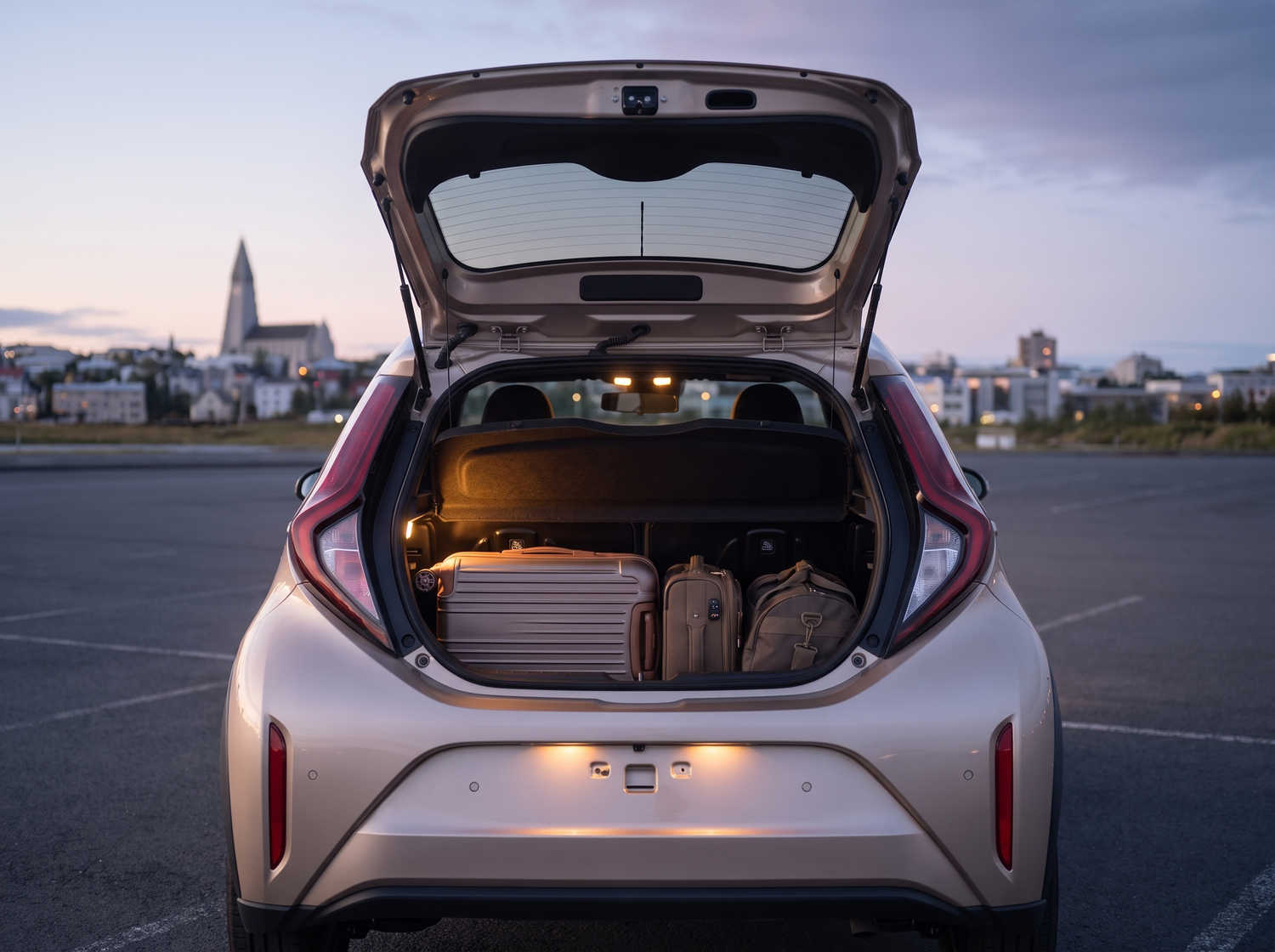 Toyota Aygo arancione brillante con cambio automatico, ideale per 4 passeggeri, compatta ed efficiente per girare le città islandesi.