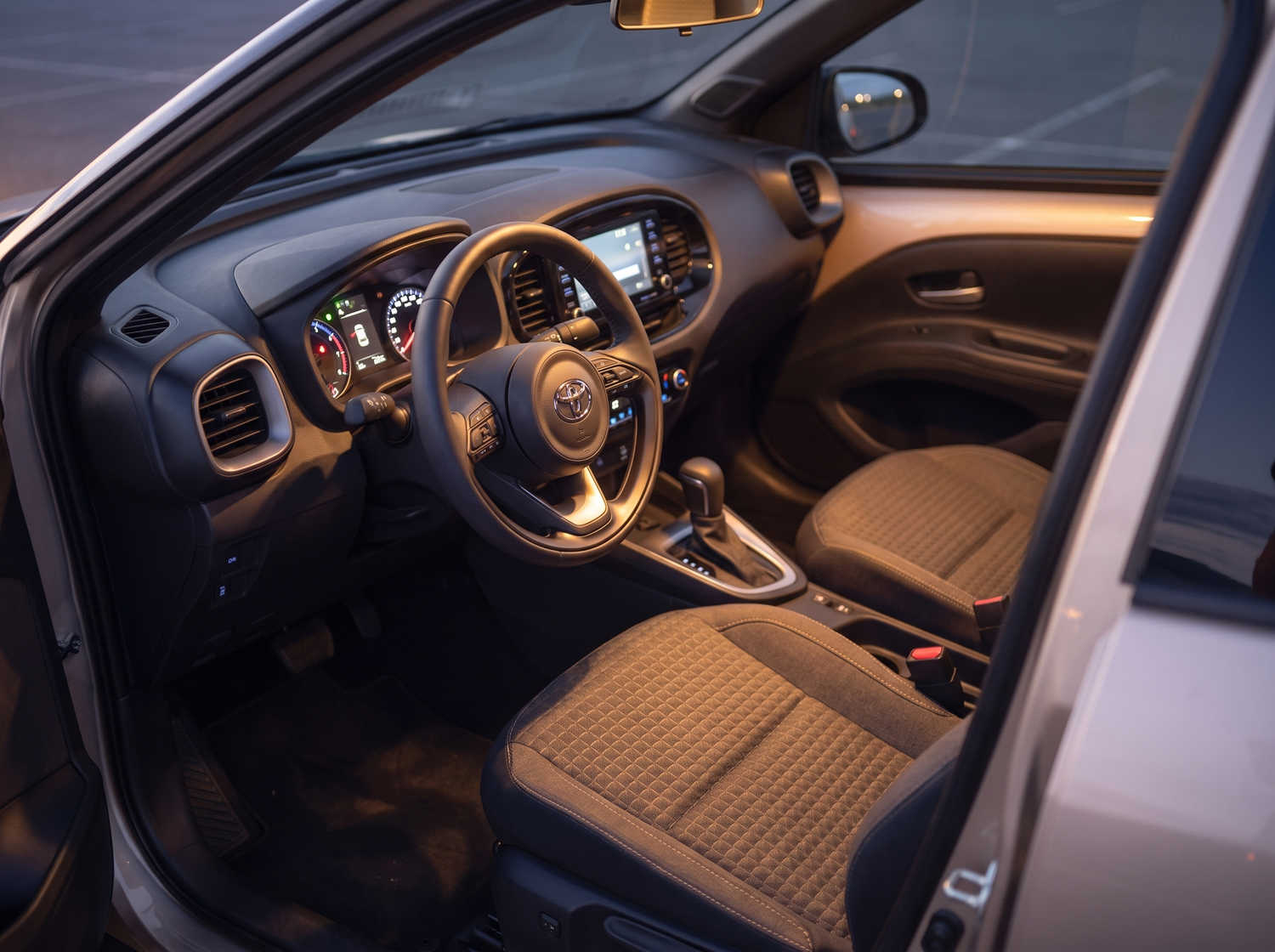Toyota Aygo arancione brillante con cambio automatico, ideale per 4 passeggeri, compatta ed efficiente per girare le città islandesi.