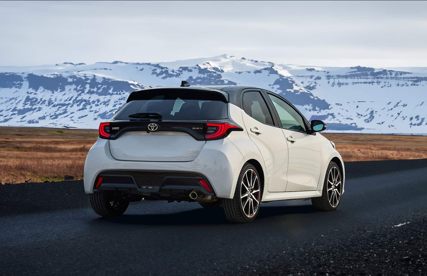 Toyota Yaris ibrida rossa con cambio automatico, 5 posti, GPS, retrocamera e spazio per 2 bagagli, ideale per viaggiare in Islanda.
