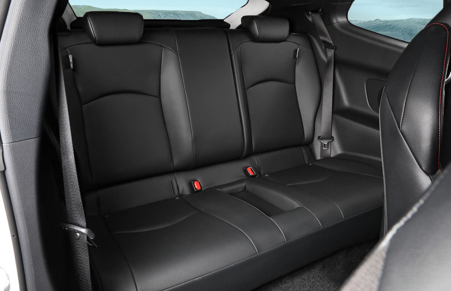 Toyota Yaris ibrida rossa con cambio automatico, 5 posti, GPS, retrocamera e spazio per 2 bagagli, ideale per viaggiare in Islanda.