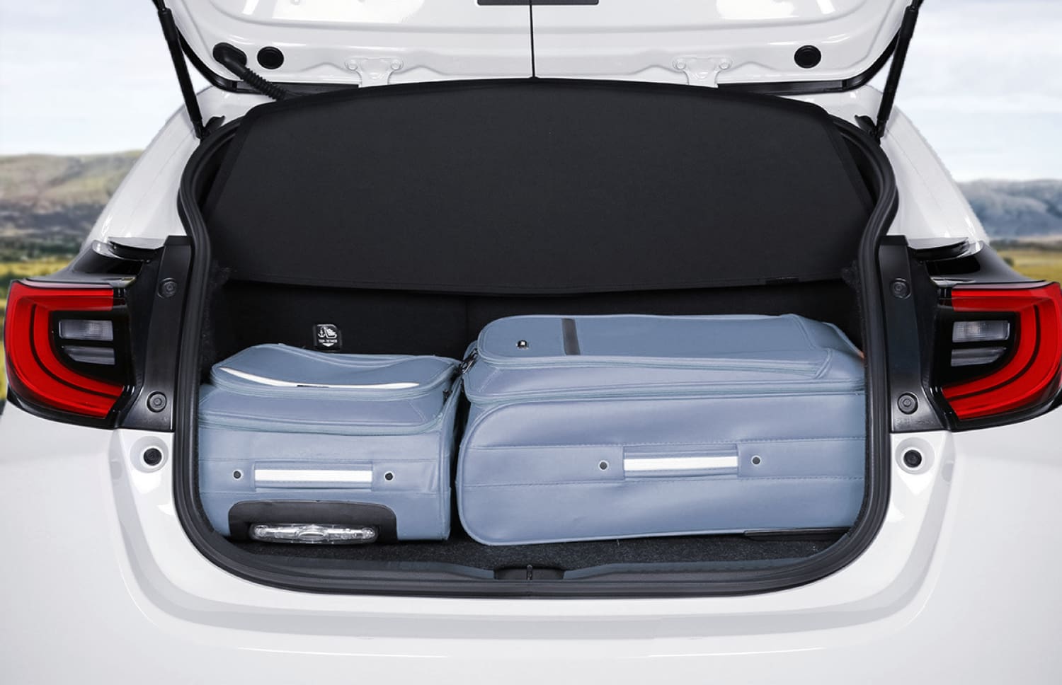 Toyota Yaris ibrida rossa con cambio automatico, 5 posti, GPS, retrocamera e spazio per 2 bagagli, ideale per viaggiare in Islanda.