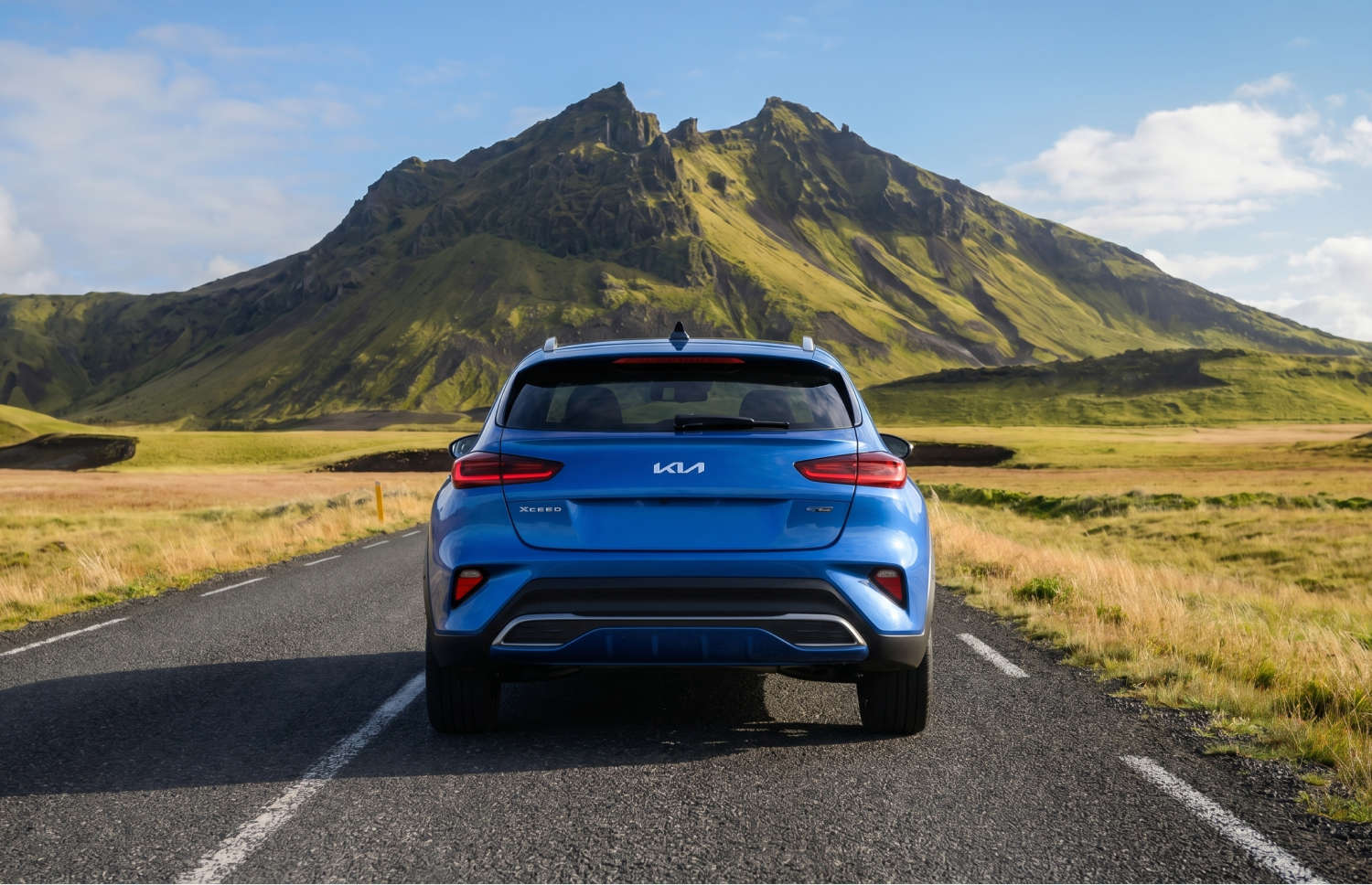 Kia XCeed crossover giallo brillante con cambio automatico, GPS, retrocamera e sedili riscaldati; 5 posti e spazio per 2 bagagli, ideale per i viaggi in Islanda.