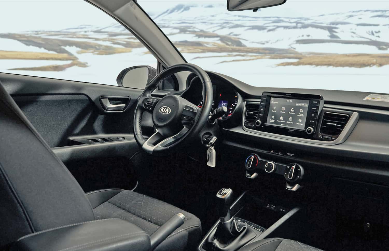 Kia Rio blu con cambio manuale, GPS, retrocamera e spazio per 5 passeggeri e 2 bagagli, ideale per i viaggi su strada in Islanda.
