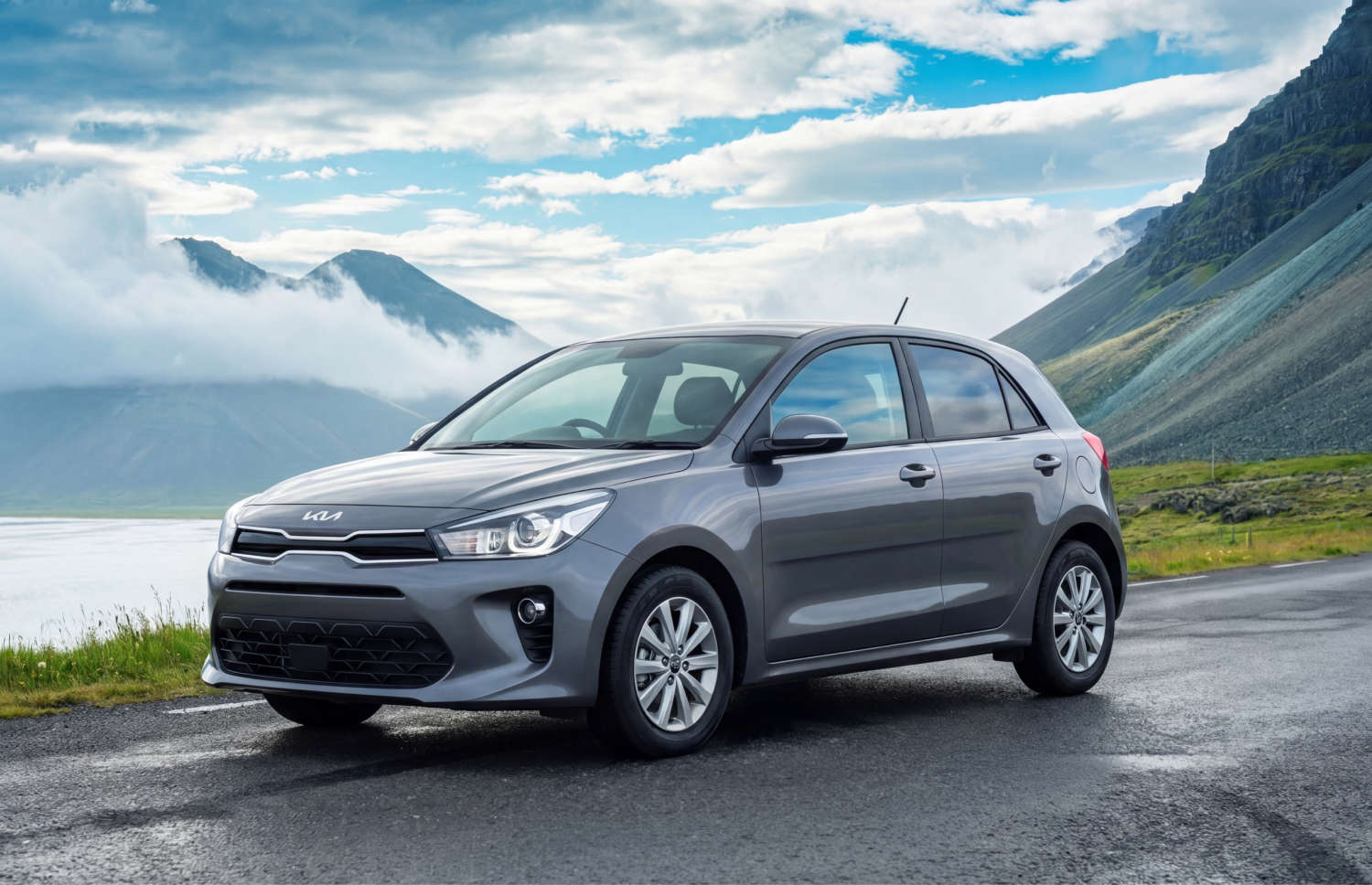 Kia Rio blu con cambio manuale, GPS, retrocamera e spazio per 5 passeggeri e 2 bagagli, ideale per i viaggi su strada in Islanda.