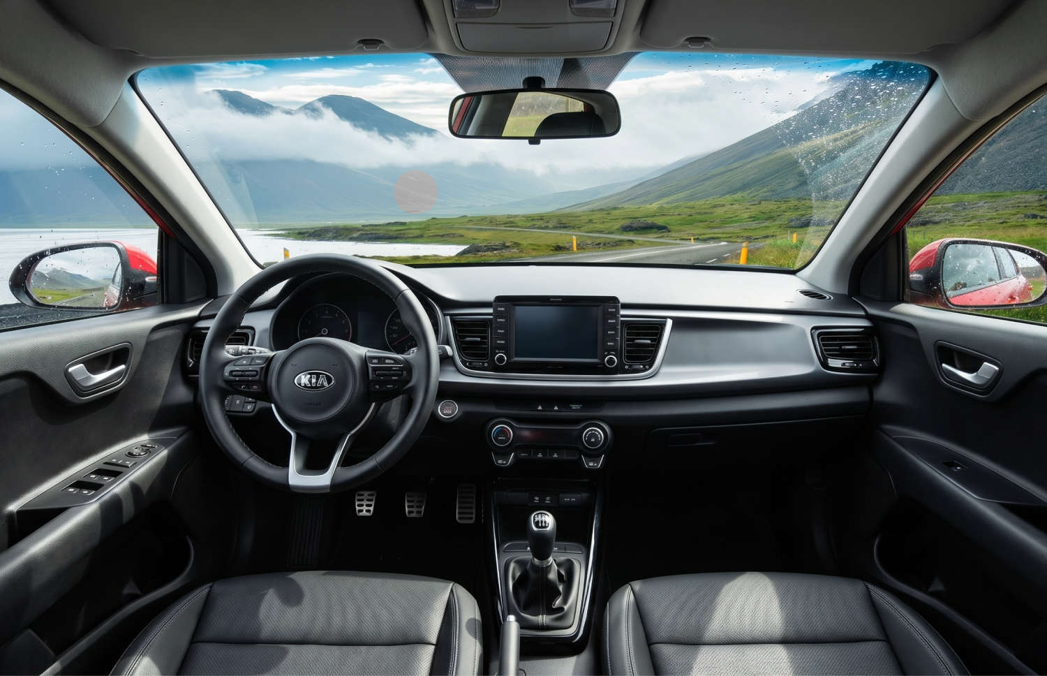 Kia Rio blu con cambio manuale, GPS, retrocamera e spazio per 5 passeggeri e 2 bagagli, ideale per i viaggi su strada in Islanda.