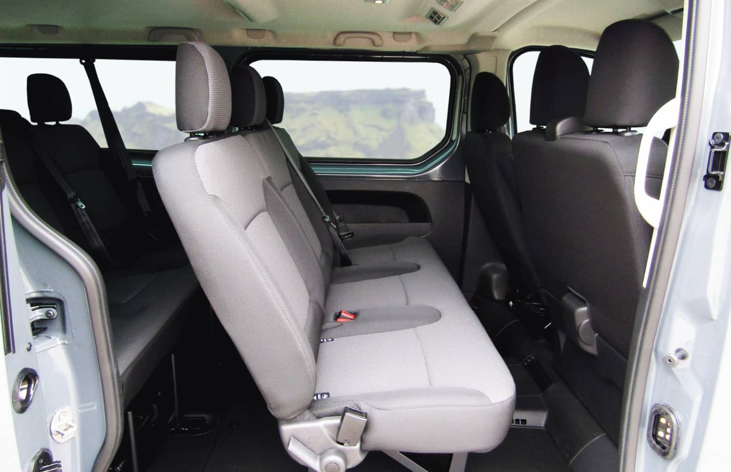 Renault Trafic rosso, furgone da 9 posti con cambio manuale, sedili riscaldati, Bluetooth e caricatore USB; ideale per i viaggi di gruppo in Islanda.