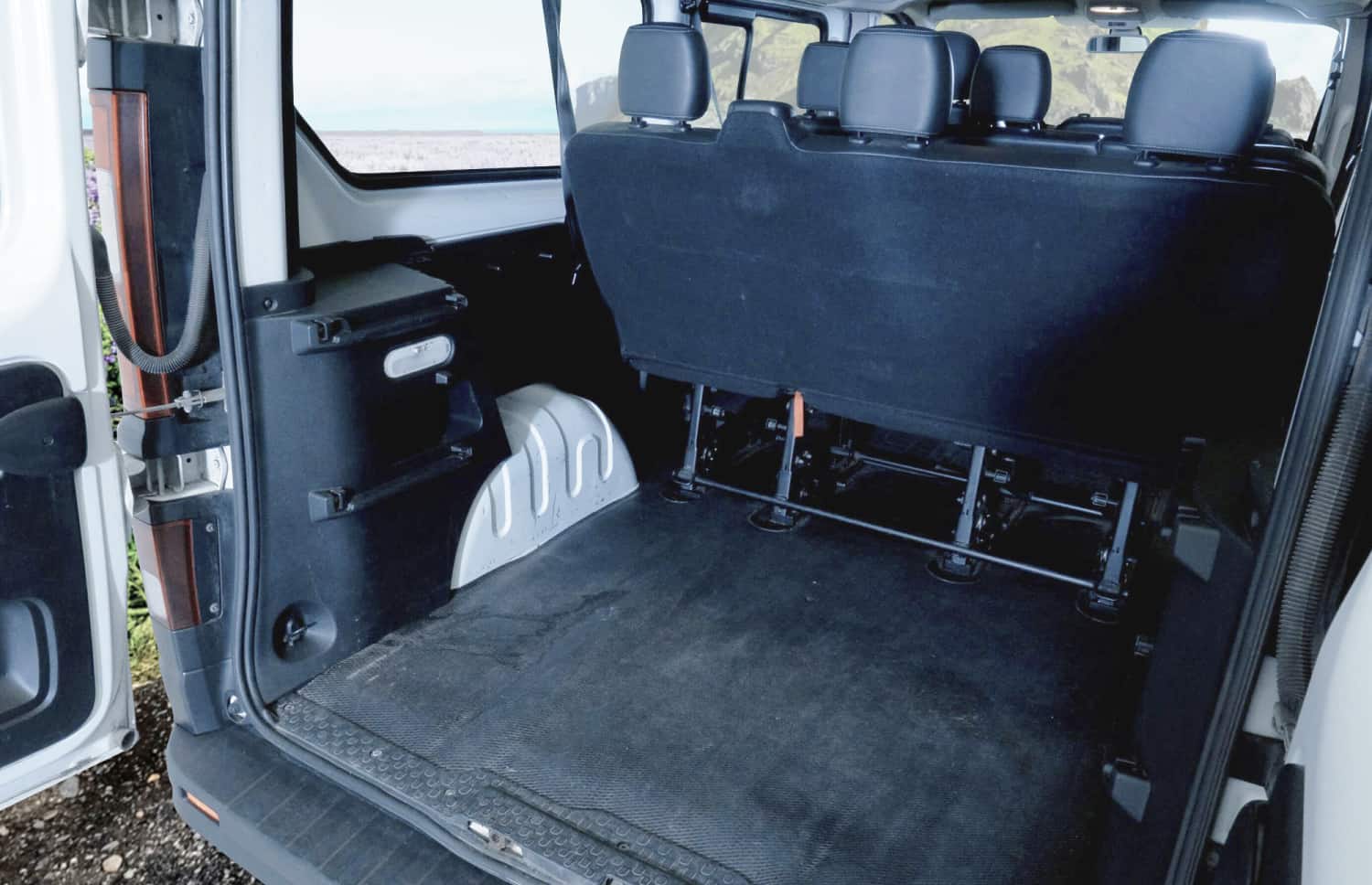 Renault Trafic rosso, furgone da 9 posti con cambio manuale, sedili riscaldati, Bluetooth e caricatore USB; ideale per i viaggi di gruppo in Islanda.