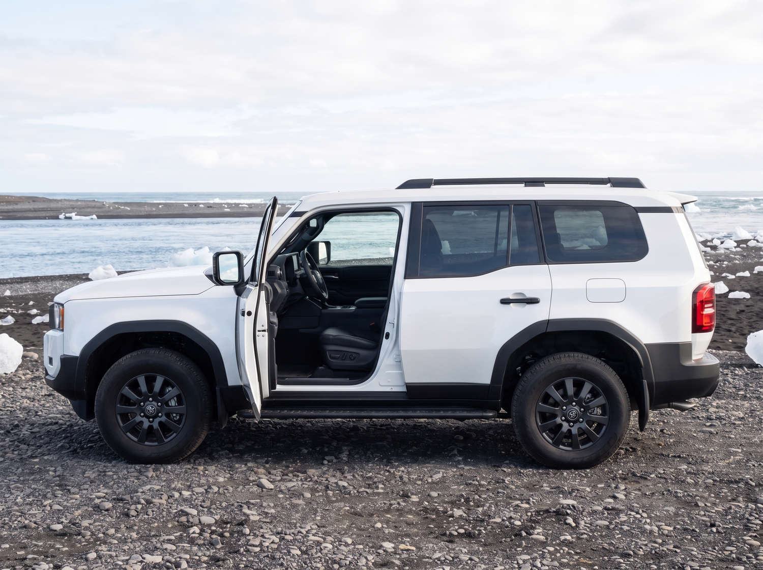 Toyota Land Cruiser 250 bianco, SUV 4x4 con cambio automatico, 7 posti, caricatore USB, Bluetooth e sedili riscaldati; perfetto per le avventure fuoristrada in Islanda.