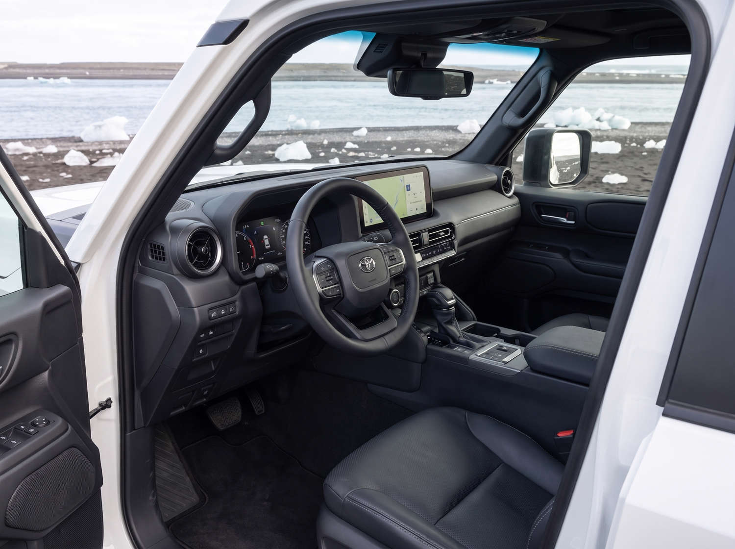 Toyota Land Cruiser 250 bianco, SUV 4x4 con cambio automatico, 7 posti, caricatore USB, Bluetooth e sedili riscaldati; perfetto per le avventure fuoristrada in Islanda.