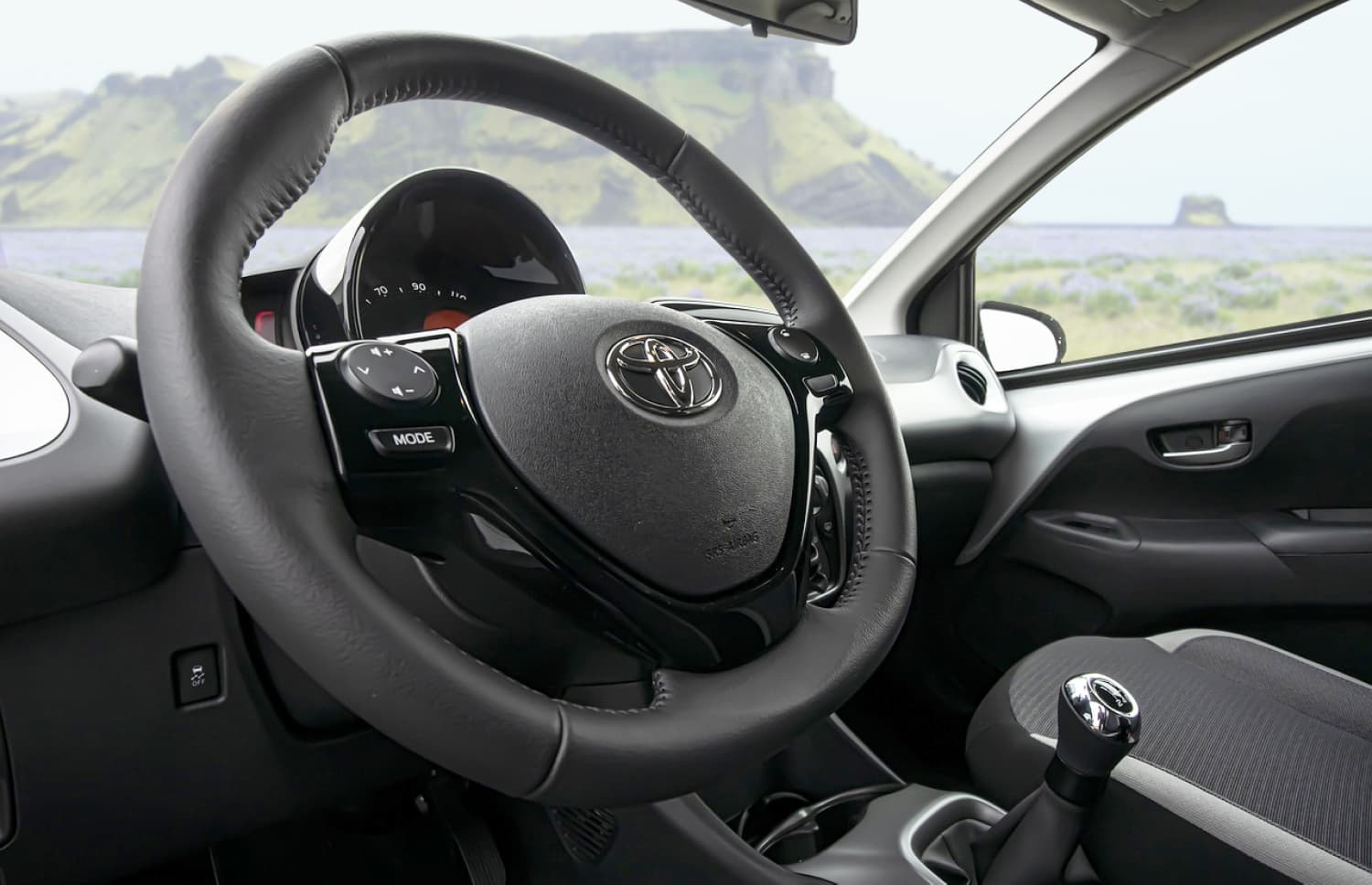 Toyota Aygo compatta grigio metallizzato con cambio manuale, perfetta per 4 passeggeri, ideale per la guida in città in Islanda.
