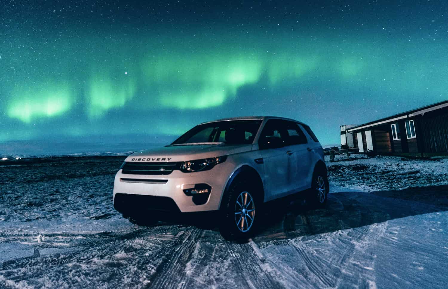 Land Rover Discovery Sport bianco, SUV 4x4 con cambio automatico, GPS, retrocamera e sedili riscaldati, ideale per 5 passeggeri in Islanda.